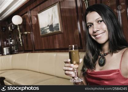 Portrait of a young woman holding a champagne flute and smiling