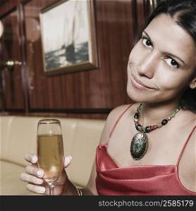 Portrait of a young woman holding a champagne flute and smiling