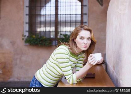 Portrait of a young woman holding a coffee cup