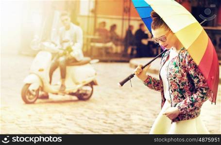 Portrait of a young woman holding a colorful umbrella