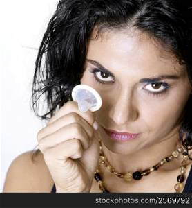 Portrait of a young woman holding a condom