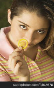 Portrait of a young woman holding a condom