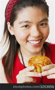 Portrait of a young woman holding a cookie and smiling
