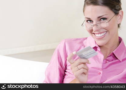 Portrait of a young woman holding a credit card