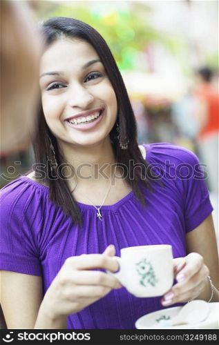Portrait of a young woman holding a cup