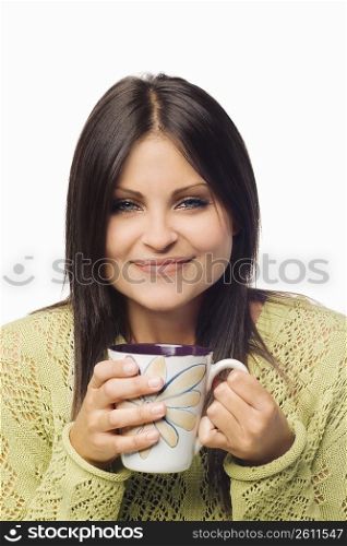 Portrait of a young woman holding a cup of coffee and smiling
