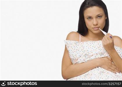 Portrait of a young woman holding a digital thermometer