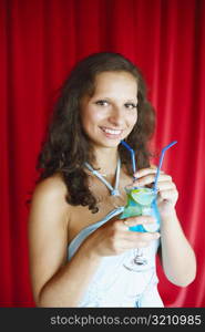 Portrait of a young woman holding a drink smiling