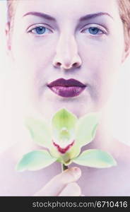 Portrait of a young woman holding a flower