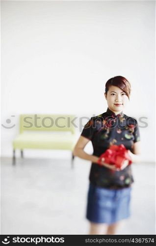 Portrait of a young woman holding a gift in her hands