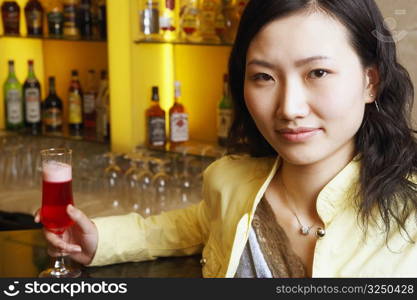 Portrait of a young woman holding a glass