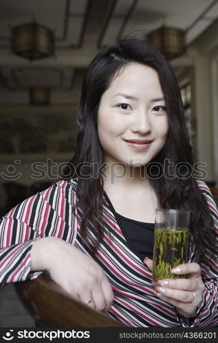 Portrait of a young woman holding a glass