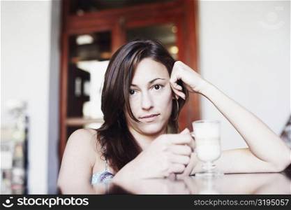 Portrait of a young woman holding a glass of coffee