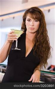 Portrait of a young woman holding a glass of martini