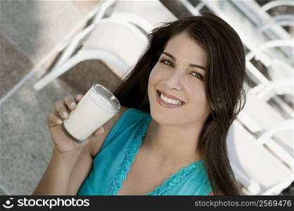 Portrait of a young woman holding a glass of milk