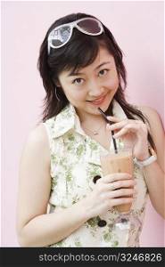 Portrait of a young woman holding a glass of milkshake