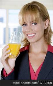 Portrait of a young woman holding a glass of orange juice