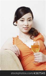 Portrait of a young woman holding a glass of wine
