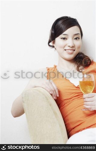 Portrait of a young woman holding a glass of wine