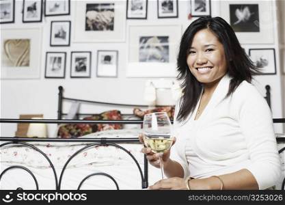 Portrait of a young woman holding a glass of wine smiling