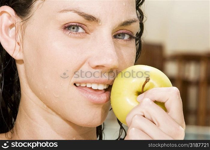 Portrait of a young woman holding a green apple