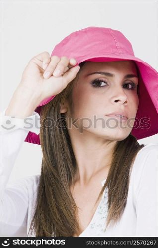 Portrait of a young woman holding a hat