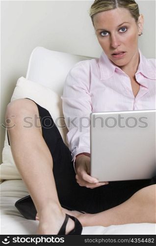 Portrait of a young woman holding a laptop
