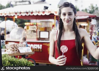 Portrait of a young woman holding a lollipop