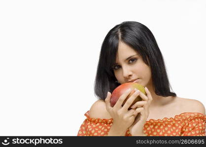 Portrait of a young woman holding a mango