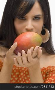 Portrait of a young woman holding a mango