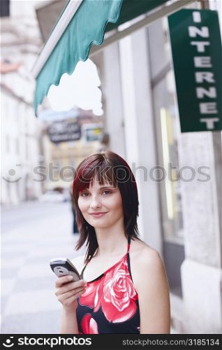 Portrait of a young woman holding a mobile phone