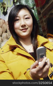 Portrait of a young woman holding a mobile phone