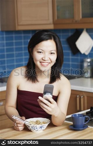 Portrait of a young woman holding a mobile phone smiling