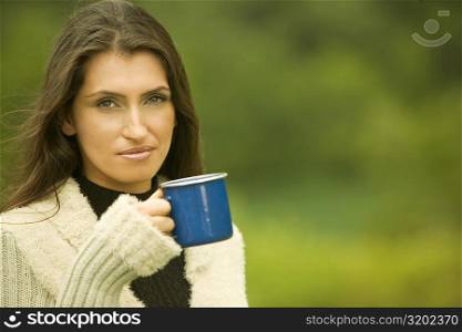 Portrait of a young woman holding a mug
