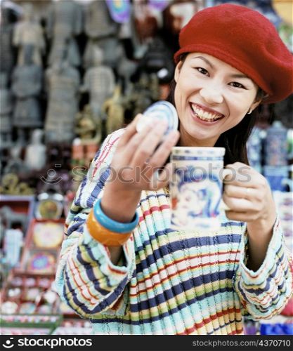 Portrait of a young woman holding a mug and smiling