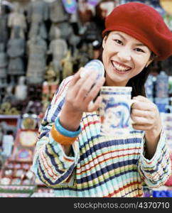 Portrait of a young woman holding a mug and smiling