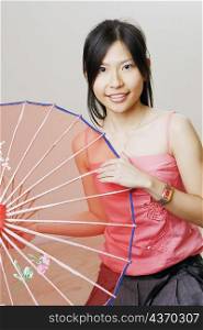 Portrait of a young woman holding a parasol and posing