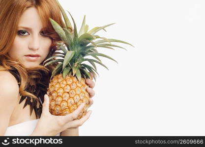 Portrait of a young woman holding a pineapple