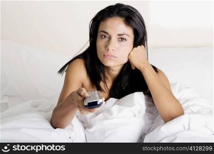 Portrait of a young woman holding a remote control