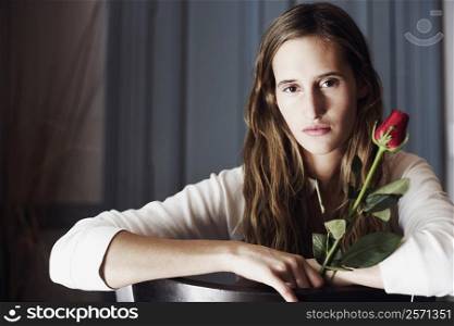 Portrait of a young woman holding a rose