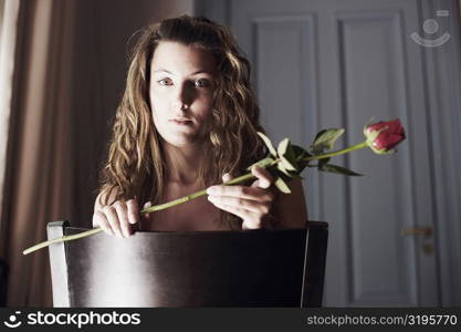 Portrait of a young woman holding a rose