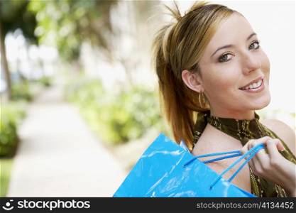 Portrait of a young woman holding a shopping bag