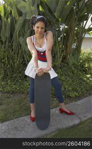 Portrait of a young woman holding a skateboard