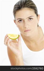 Portrait of a young woman holding a slice of lime