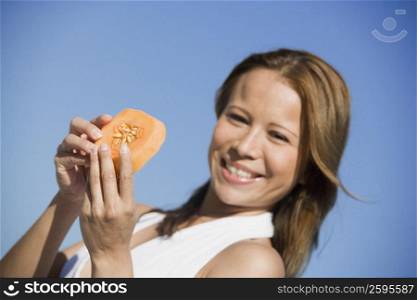 Portrait of a young woman holding a slice of melon