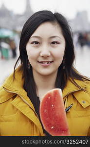 Portrait of a young woman holding a slice of watermelon