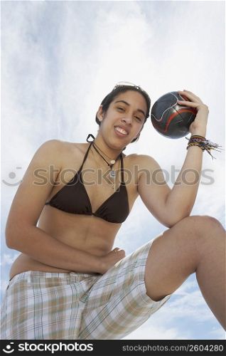 Portrait of a young woman holding a soccer ball and smiling
