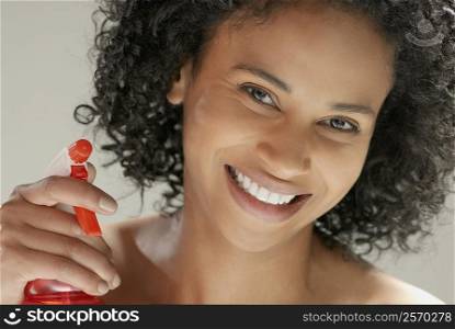 Portrait of a young woman holding a spray bottle