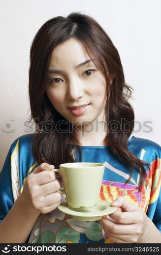 Portrait of a young woman holding a tea cup