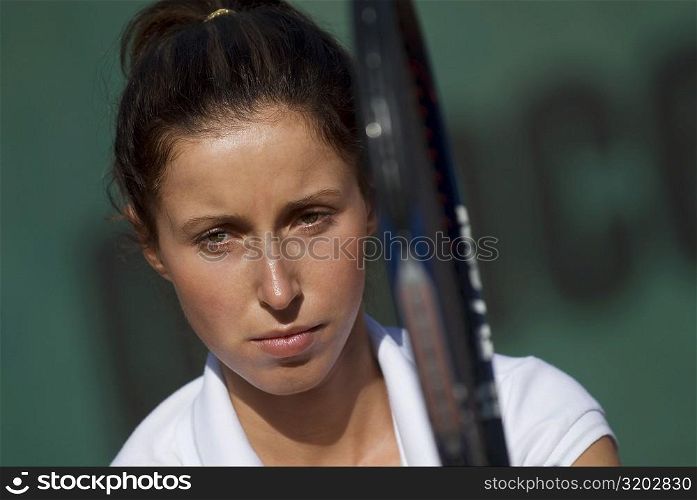Portrait of a young woman holding a tennis racket